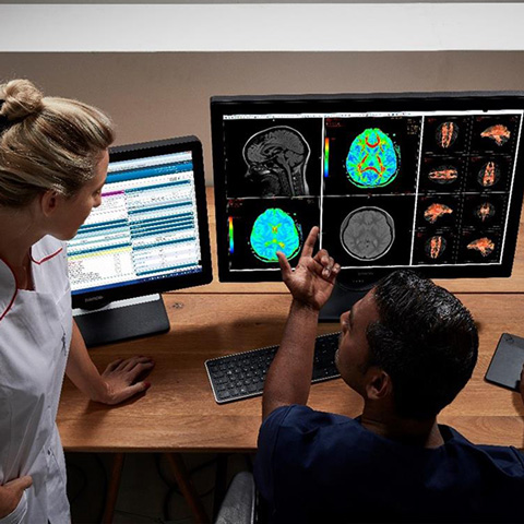 Radiologists together looking at screen